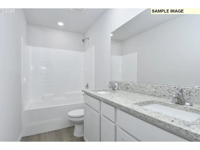 a bathroom with a granite countertop sink a toilet and shower