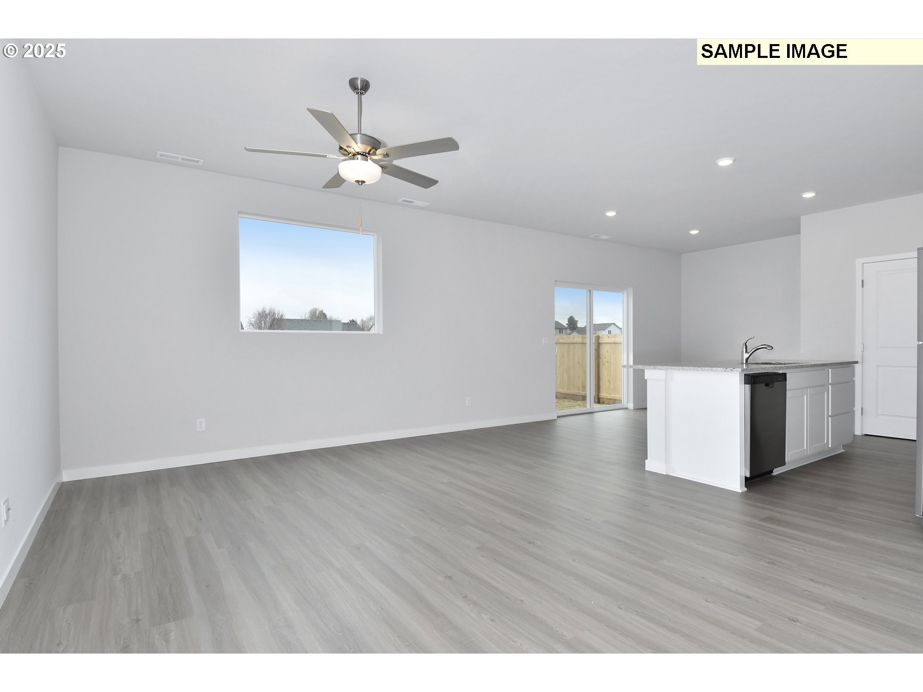 1122 Parkside Avenue Woodburn, OR 97071 - Photo 5 of 22 a view of an empty room with wooden floor and a ceiling fan