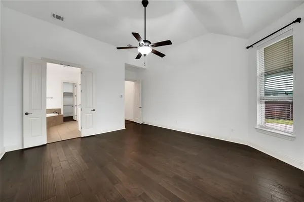 a view of a livingroom with wooden floor and a ceiling fan
