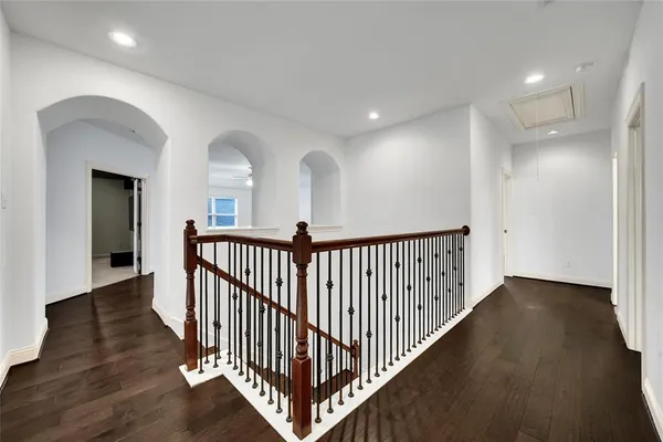 a view of a hallway with wooden floor and windows