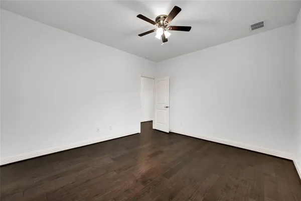 an empty room with a ceiling fan and a window