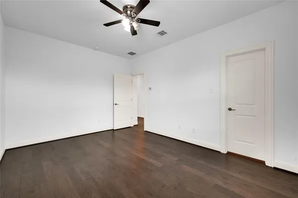 an empty room with a ceiling fan and window