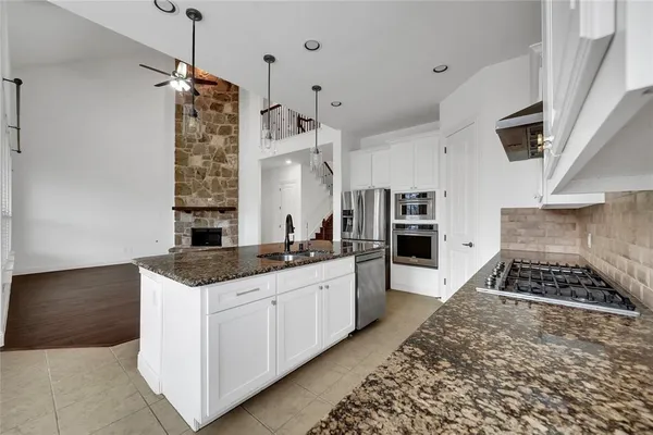 a kitchen with granite countertop a stove and a refrigerator