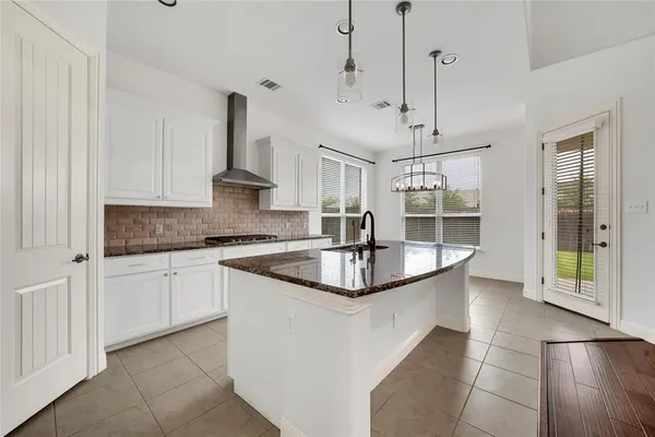 a kitchen with kitchen island granite countertop a sink a counter space appliances and cabinets