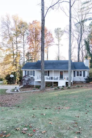 a view of a big house with a big yard and large trees