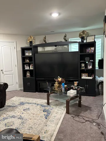 a living room with furniture a rug and a flat screen tv