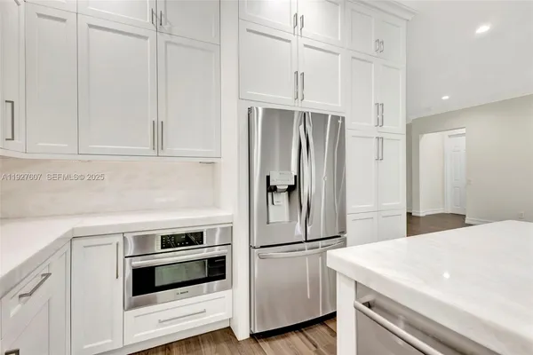 a kitchen with stainless steel appliances white cabinets and white appliances
