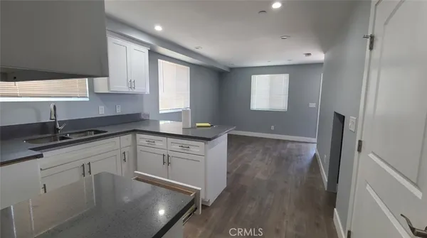 a kitchen with a sink cabinets and wooden floor