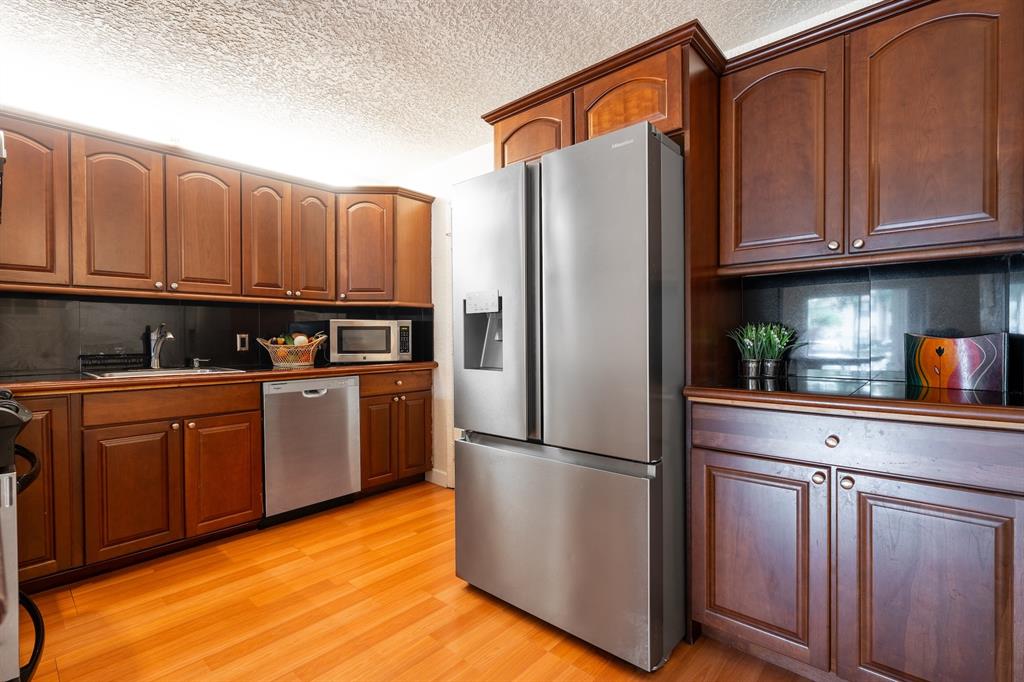 22605 Southwest 66th Avenue, Unit 102 Boca Raton, FL 33428 - Photo 6 of 27 a kitchen with stainless steel appliances granite countertop a refrigerator sink and cabinets