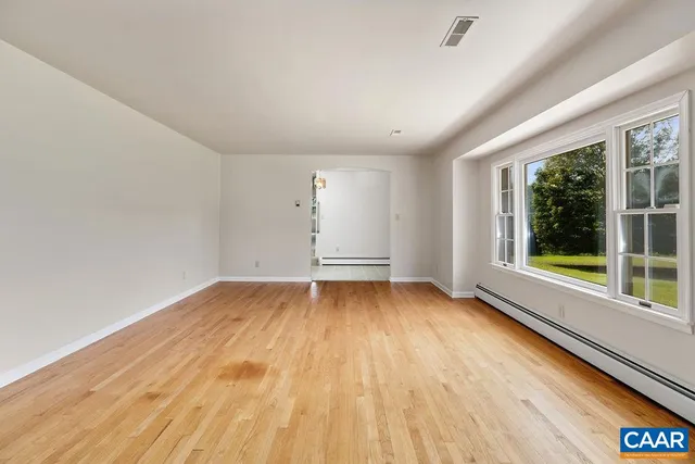 a view of empty room with wooden floor and fireplace