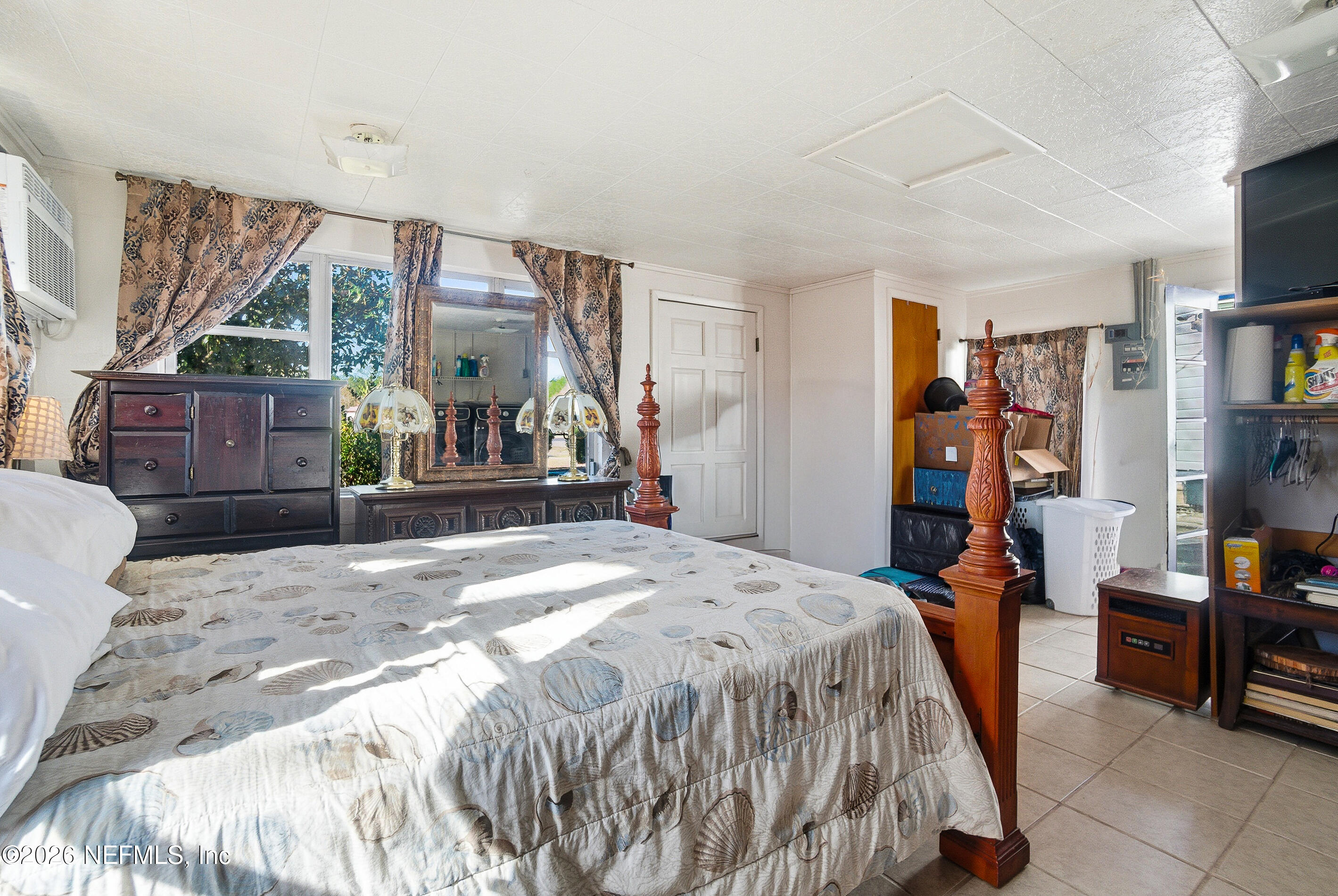 18273 Highway 16 Starke, FL 32091 - Photo 20 of 42 a bedroom with a bed a large window and book shelf