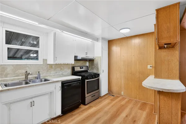 a kitchen with a sink a stove a refrigerator and cabinets