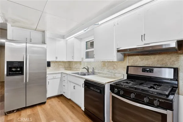 a kitchen with stainless steel appliances a sink a stove and a refrigerator