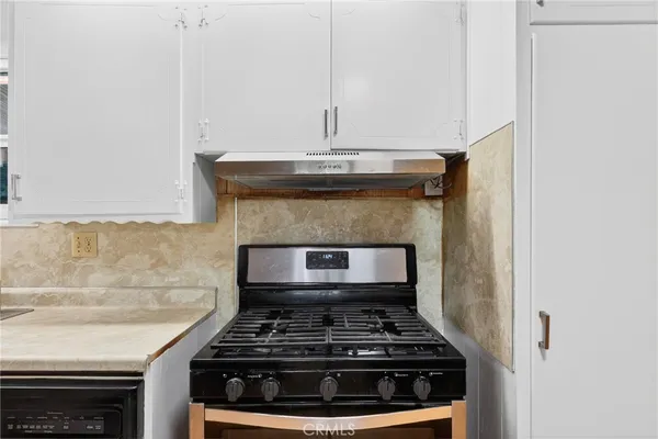 a kitchen with granite countertop white cabinets and a sink
