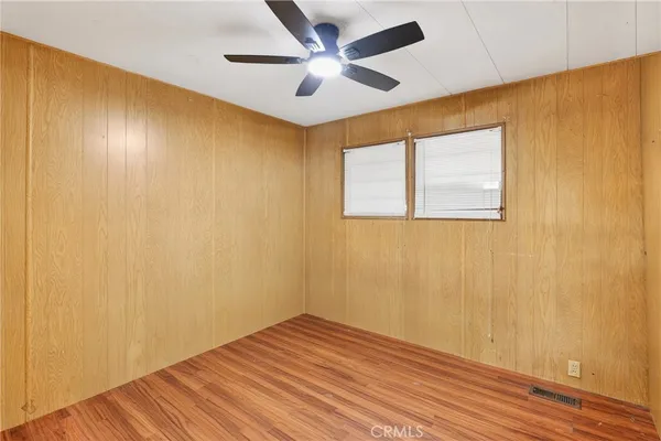 a view of empty room with wooden floor