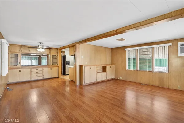 a view of a big room with wooden floor and windows