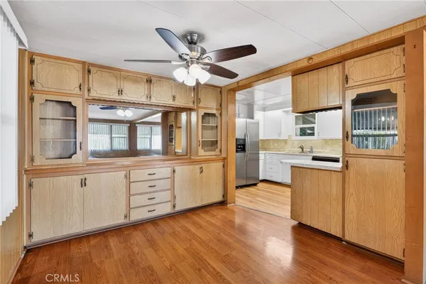 a kitchen with stainless steel appliances granite countertop a refrigerator a stove and a sink with wooden floors