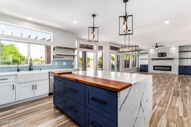 a kitchen with kitchen island granite countertop a sink stove and refrigerator