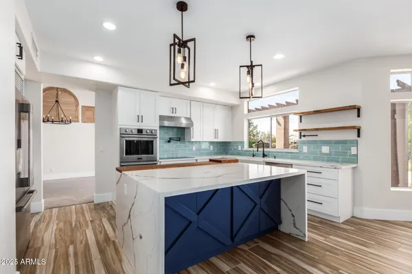a walk in closet with wooden floor