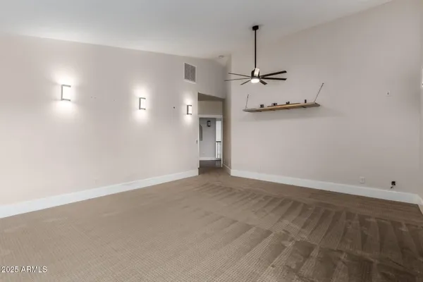 an empty room with a ceiling fan and window