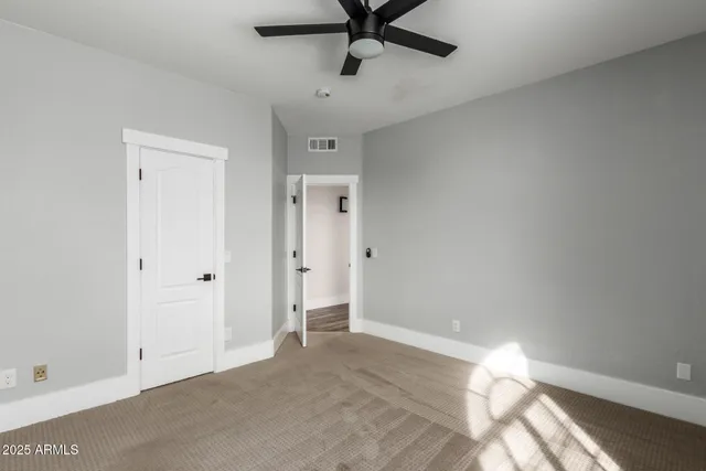 an empty room with closet and windows