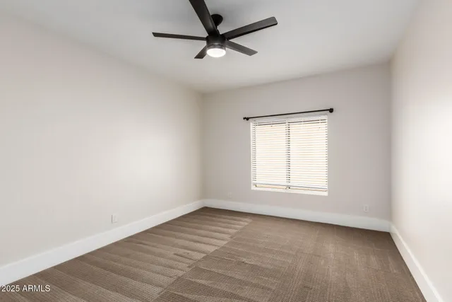 a view of empty room with ceiling fan