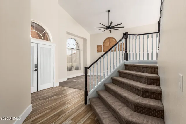a view of an empty room with chandelier fan