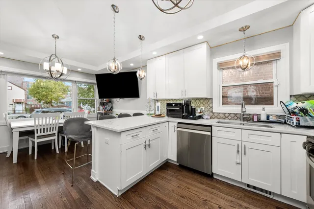 a kitchen with a white cabinets and chairs
