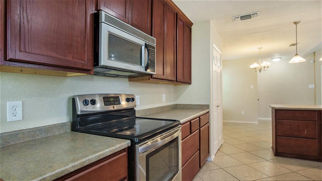 7600 Silveridge Drive Fort Worth, TX 76133 - Photo 13 of 24 a kitchen with a stove and a microwave