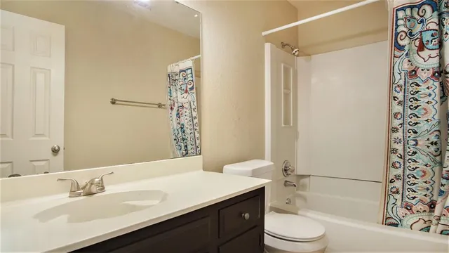 a bathroom with a sink a toilet a mirror and shower