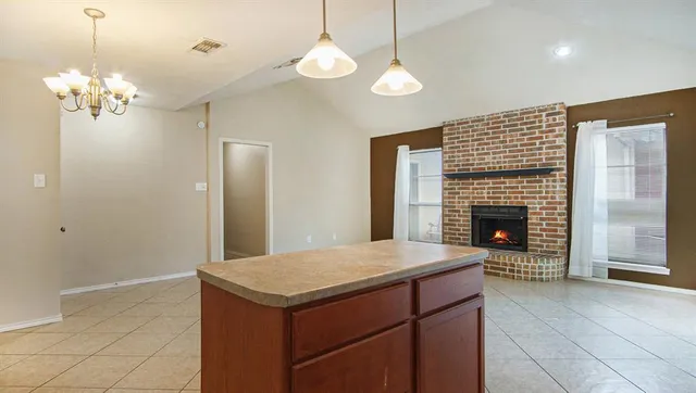a view of kitchen with granite countertop cabinets and fireplace