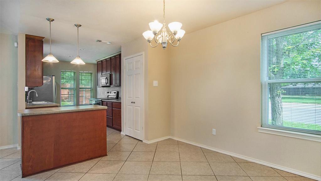 7600 Silveridge Drive Fort Worth, TX 76133 - Photo 9 of 24 a dining hall with a window and a chandelier