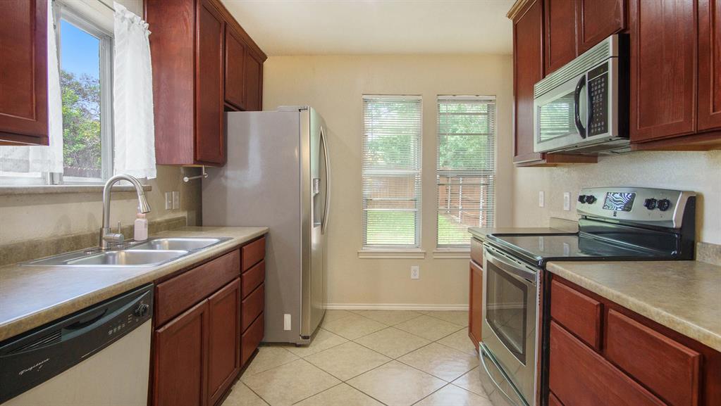 7600 Silveridge Drive Fort Worth, TX 76133 - Photo 10 of 24 a kitchen with stainless steel appliances granite countertop a sink stove and cabinets