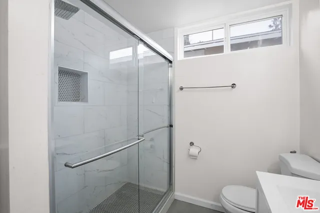 a bathroom with a toilet and a shower