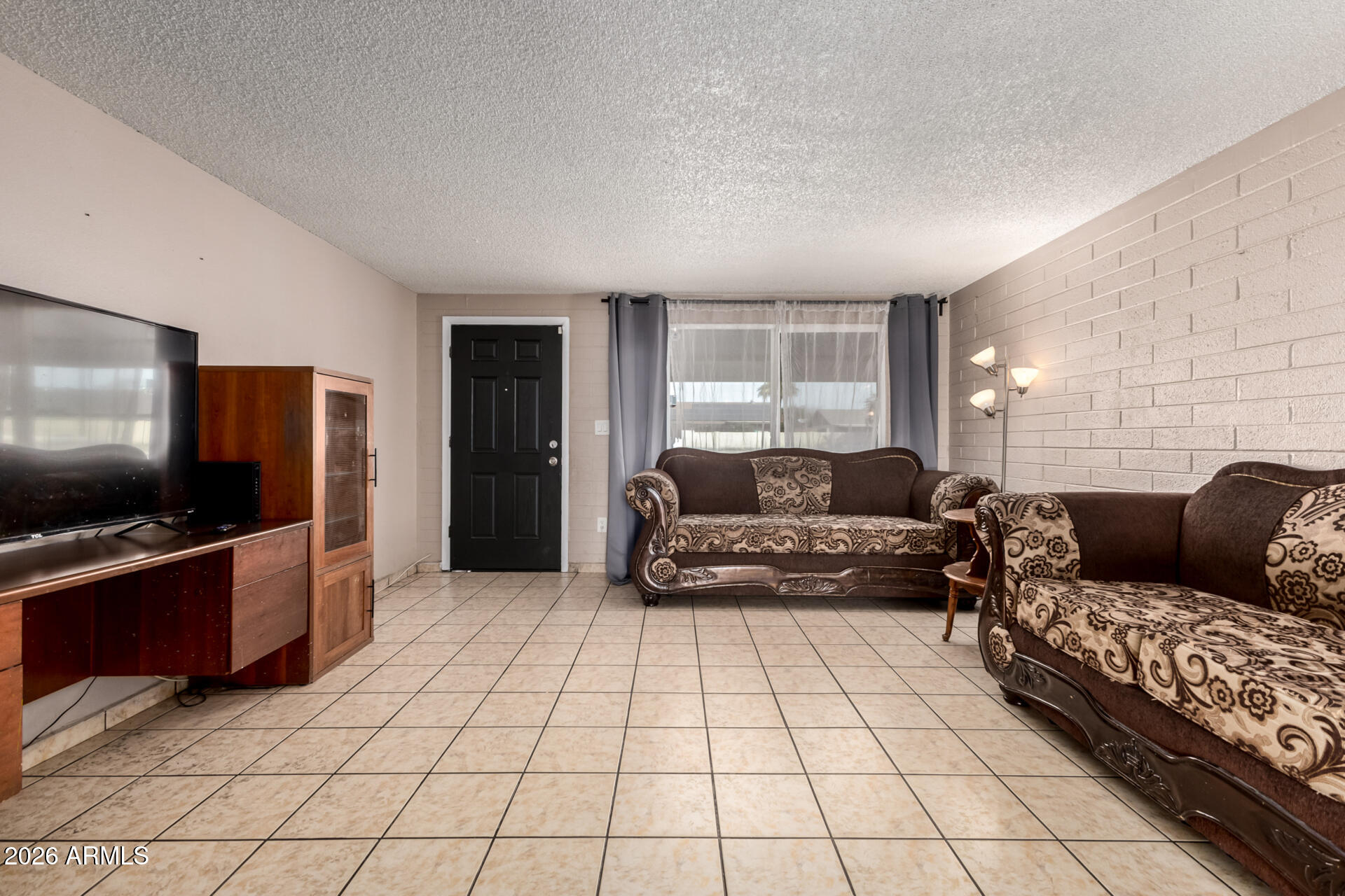 7265 West Camelback Road Phoenix, AZ 85033 - Photo 8 of 31 a living room with furniture and a flat screen tv