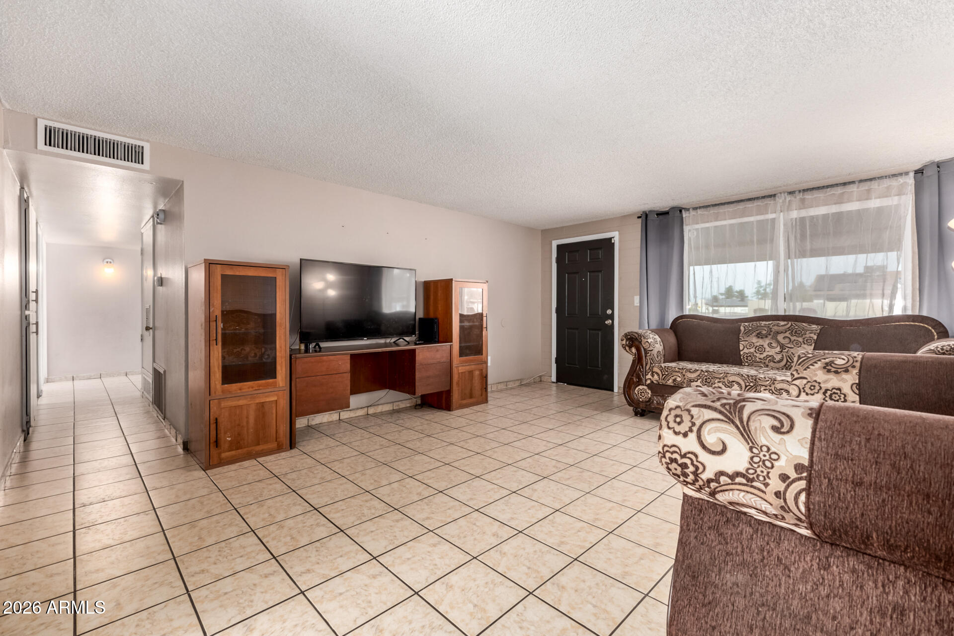 7265 West Camelback Road Phoenix, AZ 85033 - Photo 10 of 31 a living room with furniture and a flat screen tv