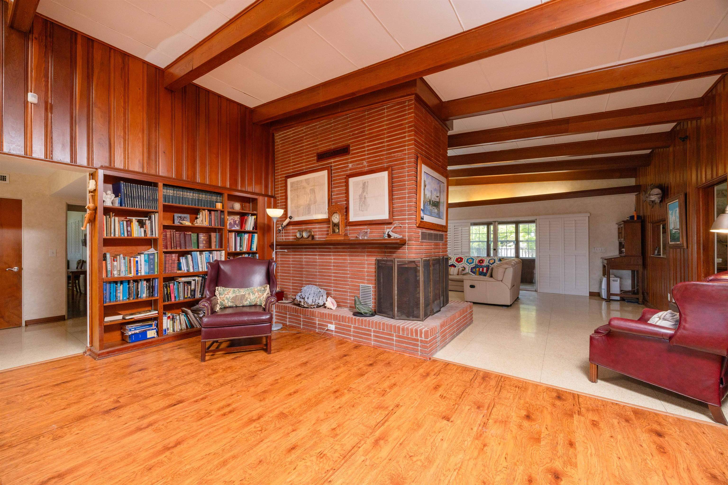 124 Inlet Drive St. Augustine, FL 32080 - Photo 29 of 45 Living area with beamed ceiling, wood walls, a fireplace, and light wood-type flooring