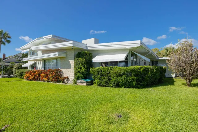 a front view of a house with a garden