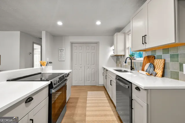 a kitchen with stainless steel appliances granite countertop a sink stove and cabinets