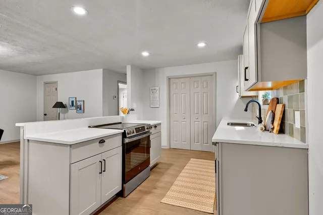 a kitchen with white cabinets appliances and sink