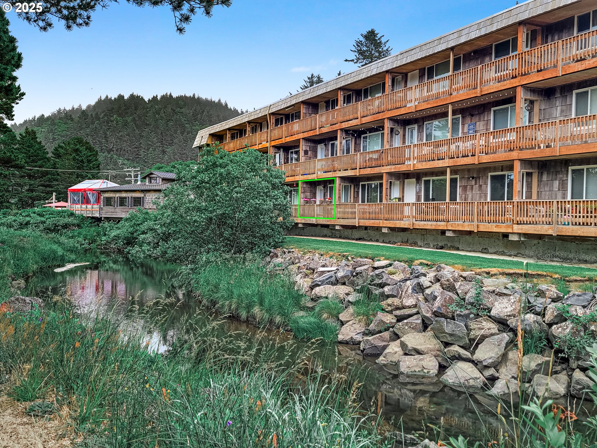 48988 Highway 101, Unit 137F Neskowin, OR 97149 - Photo 22 of 29 a large building with a small yard and trees