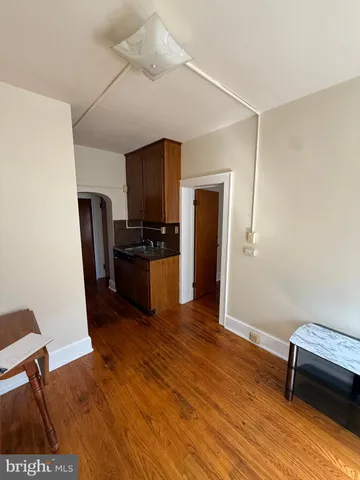 a view of kitchen with refrigerator stove and wooden floor