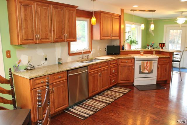 902 North Summit Road Bath, PA 18014 - Photo 5 of 36 a kitchen with stainless steel appliances granite countertop wooden cabinets a sink and dishwasher with wooden floor
