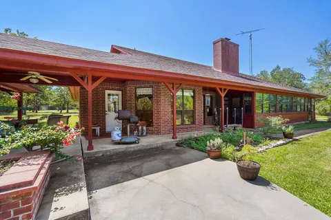 a view of a patio with table and chairs potted plants and floor to ceiling window