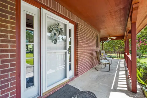 a view of a porch with wooden floor and a yard