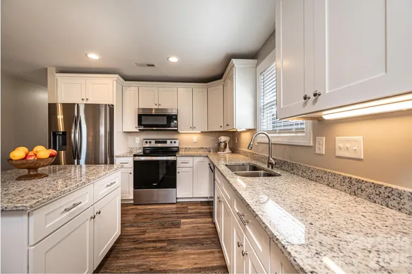 a kitchen with stainless steel appliances granite countertop a refrigerator stove microwave and sink