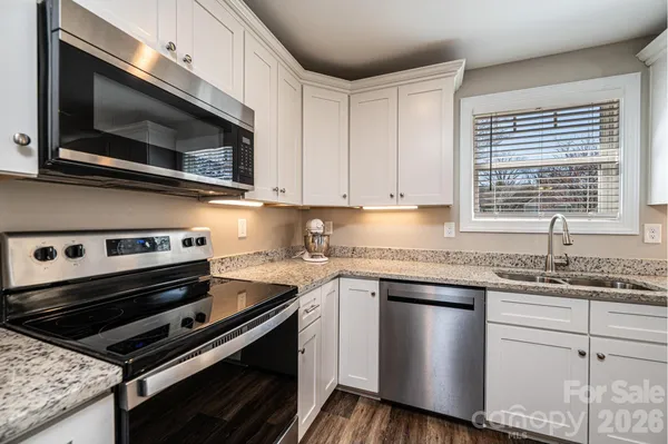 a kitchen with stainless steel appliances a sink stove and microwave