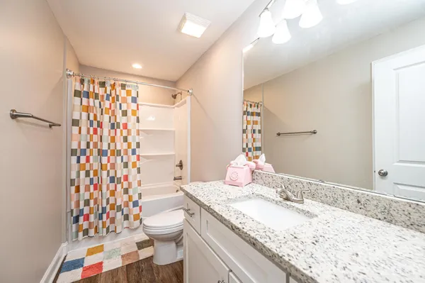 a bathroom with a granite countertop sink toilet and shower