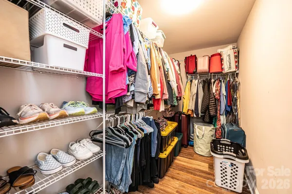 a view of walk in closet with clothes and shoes