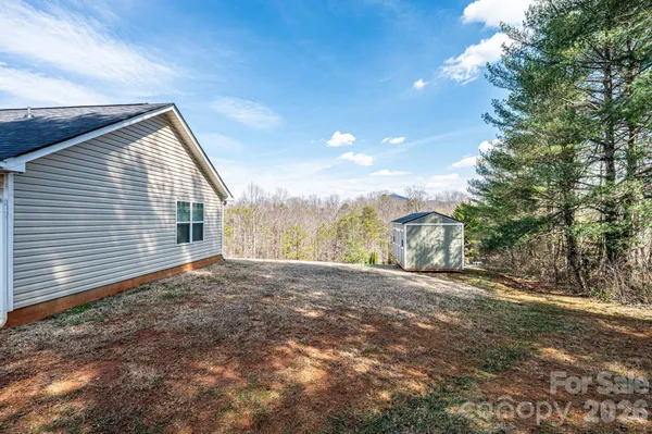 a view of a house with a yard and mountain view in back
